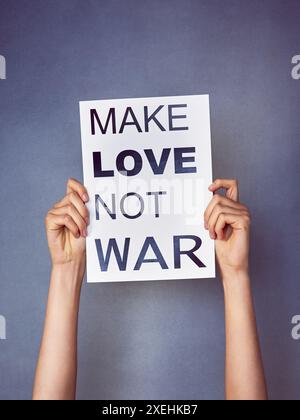 Studio, mani e poster con testo per protesta di guerra con unità, pace e solidarietà su sfondo grigio. Persona, attivismo e striscioni o carta per umani Foto Stock