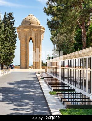 Baku, Azerbaigian - 6 maggio 2024: Il vicolo dei martiri, commemora i soldati morti nella guerra del Nagorno-Karabakh. Presenta tombe dei soldati e monumento centrale con una torre solitaria che ospita la fiamma eterna Foto Stock