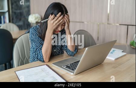 Concetto di Burnout. Donna d'affari asiatica toccare la fronte avendo mal di testa lavoro noioso e stanco dolore emotivo e professionale per Foto Stock