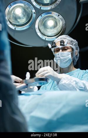 Ritratto verticale ad angolo basso della donna matura che esegue un intervento chirurgico sotto la lampada chirurgica in sala operatoria Foto Stock