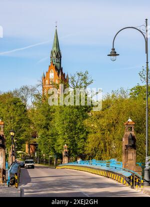 Elk, Polonia - 3 maggio 2024: Vista panoramica della città di Elk con ponte storico e chiesa neo gotica nel cuore più sacro di Gesù sul lago Jezioro Elckie Foto Stock