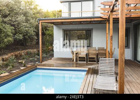 Patio esterno con mobili in legno e piscina, ambiente moderno e spazio per fotocopie Foto Stock