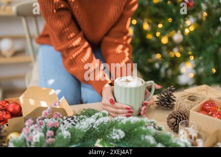 Donna che regge una tazza di cacao aromatico con marshmallow. Vigilia di Natale con una tazza di gustosa cioccolata calda atmosfera accogliente per le vacanze a. Foto Stock