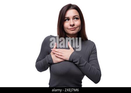 Giovane donna bruna casual che indossa un dolcevita color palude su sfondo bianco, primo piano Foto Stock