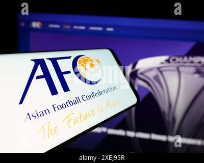 Smartphone con logo dell'associazione Asian Football Confederation (AFC) davanti al sito Web. Mettere a fuoco la parte centrale sinistra del display del telefono. Foto Stock