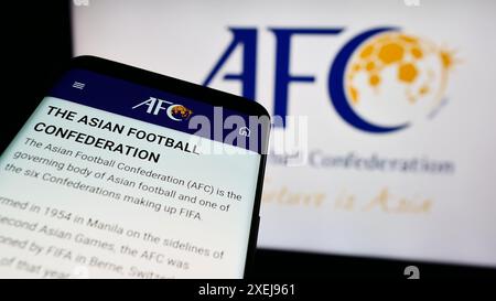 Telefono cellulare con sito web dell'associazione Asian Football Confederation (AFC) davanti al logo. Mettere a fuoco in alto a sinistra sul display del telefono. Foto Stock