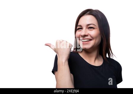 Giovane donna dai capelli neri che indossa una T-shirt nera su sfondo bianco con spazio per la copia Foto Stock