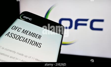 Telefono cellulare con pagina web dell'associazione Oceania Football Confederation (OFC) davanti al logo. Mettere a fuoco in alto a sinistra sul display del telefono. Foto Stock