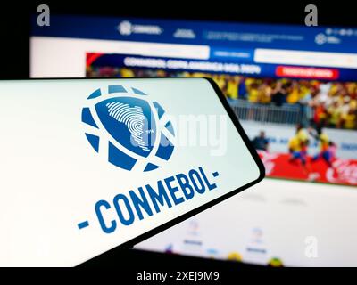 Smartphone con logo Confederacion Sudamericana de Futbol (CONMEBOL) davanti al sito Web. Mettere a fuoco la parte centrale destra del display del telefono. Foto Stock