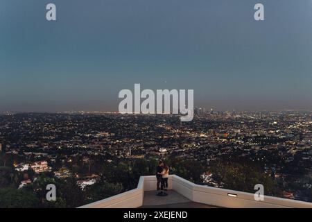 Abbracciare una coppia che guarda il centro di Los Angeles da un punto panoramico del parco Foto Stock