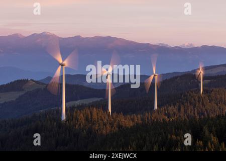 Un gruppo di centrali eoliche in movimento su un crinale di montagna alla luce del mattino Foto Stock