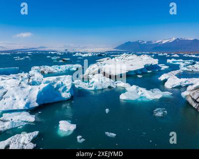 Vista aerea dei grandi pezzi di ghiaccio dal ghiacciaio, dalle isole di ghiaccio, dal ghiacciaio e dalle montagne, Jokulsarlon Foto Stock