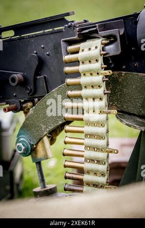 Vista dettagliata e ravvicinata di una cintura di munizioni della seconda guerra mondiale, appesa al lato di una mitragliatrice pronta a caricarsi nella breccia Foto Stock