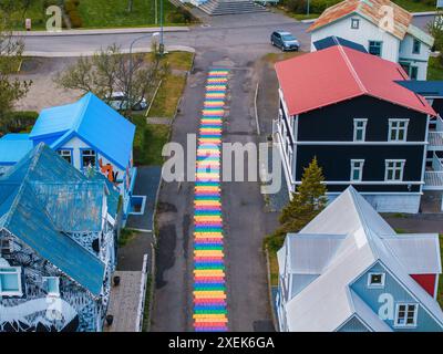 La famosa strada arcobaleno a Seydisfjordur con edifici islandesi intorno mostrano opere d'arte dipinte sulle pareti. Foto Stock