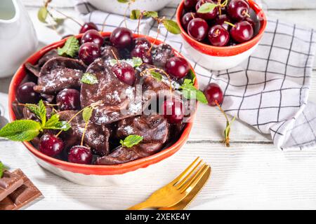 Dolci gnocchi di cioccolato vareniki con ciliegie e salsa al cioccolato, con zucchero in polvere. ucraino tradizionale, polacco, pi dell'europa orientale Foto Stock