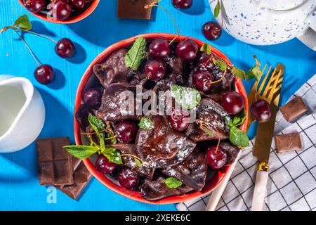 Dolci gnocchi di cioccolato vareniki con ciliegie e salsa al cioccolato, con zucchero in polvere. ucraino tradizionale, polacco, pi dell'europa orientale Foto Stock