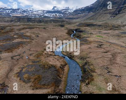 Vista aerea di un fiume Serpentine attraverso una valle innevata in Islanda Foto Stock