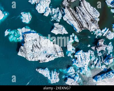 Vista aerea dei grandi pezzi di ghiaccio dal ghiacciaio, dalle isole di ghiaccio, dal ghiacciaio e dalle montagne, Jokulsarlon Foto Stock