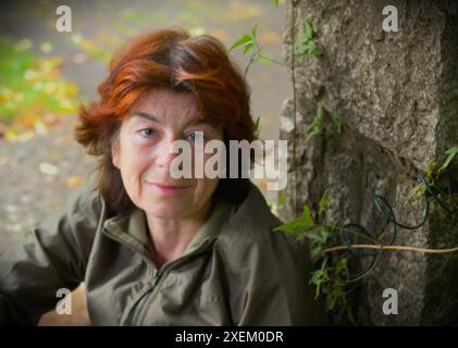 Autoritratto - autentico ritratto naturale di una donna di mezza età senza trucco in un parco Foto Stock