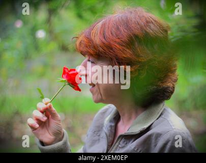 Autoritratto - autentico ritratto naturale di una donna di mezza età senza trucco in un parco Foto Stock