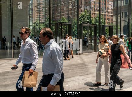 Gli impiegati con i loro pranzi da asporto si uniscono ai turisti e agli altri visitatori mentre tornano al complesso Manhattan West di New York martedì 25 giugno 2024 (© Richard B. Levine) Foto Stock