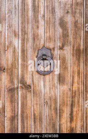 Parte di una grande porta in legno con maniglia in ferro e anello. Spagna Foto Stock