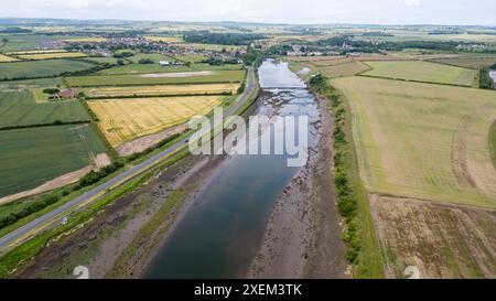 Vista aerea del fiume Coquet a Amble e del castello di Warkworth in lontananza, Northumberland, Inghilterra. Foto Stock