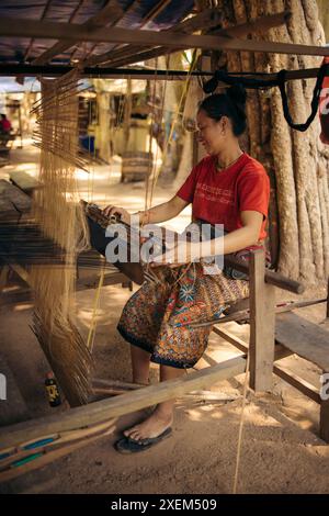 Donna che usa un telaio nel villaggio di Ban Phahom, Laos; Ban Phahom, provincia di Vientiane, Laos Foto Stock