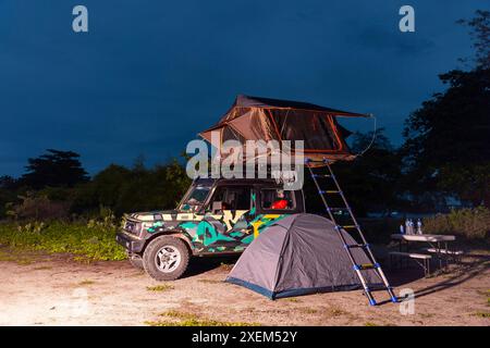 Campeggio di notte con una tenda sul tetto e una tenda sul terreno sottostante a Pantai Puru Kambera Foto Stock