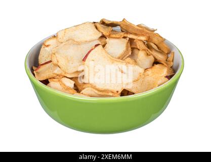 Primo piano di fette di mele essiccate in una ciotola verde isolata su sfondo bianco. Sano spuntino croccante in porcellana rotonda piena di deliziose patatine di frutta. Foto Stock