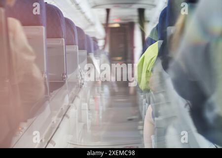 Immagine sfocata di una corsia stretta nella cabina passeggeri lungo la corsia. Luce del giorno nella cabina della compagnia aerea. Con spazio per copiare. Foto di alta qualità Foto Stock