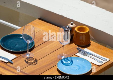 Prima dell'ora di pranzo, un elegante e vuoto caffè sulla spiaggia con tavoli serviti che aspettano gli ospiti nella soleggiata Biarritz, Paesi Baschi, Francia Foto Stock