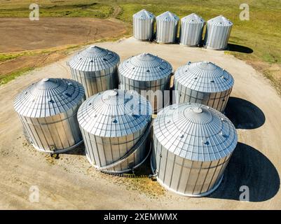 Vista aerea di grandi contenitori di grano metallico sui terreni agricoli a nord di Calgary, Alberta; Alberta, Canada Foto Stock