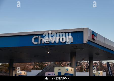 Burnaby, CANADA - 8 dicembre 2023: Un segno di un negozio della società energetica statunitense Chevron (Chevron Corporation) visto in una stazione di servizio in serata. Foto Stock