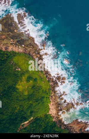 Vista aerea della costa frastagliata e della vegetazione lussureggiante di Seger Beach; Kuta, Kecamatan Pujut, Kabupaten Lombok Tengah, Nusa Tenggara Barat, Indonesia Foto Stock