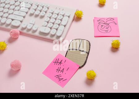 Tastiera per computer con mouse in cartone, note adesive e decorazioni su sfondo rosa. April Fools Day Pank Foto Stock