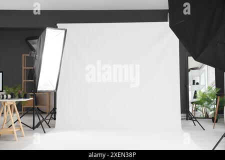 Interno di un moderno studio fotografico con attrezzature professionali e sfondo bianco Foto Stock