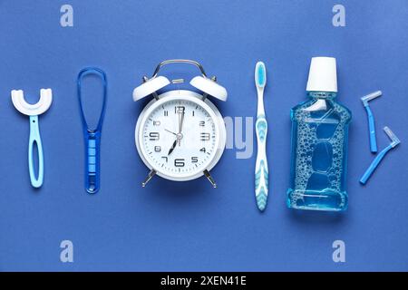 Sveglia e set per igiene orale su sfondo blu Foto Stock