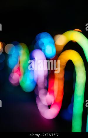 Luci sfocate e multicolore di un'installazione artistica che si snoda contro un cielo notturno; Bangkok, Thailandia Foto Stock