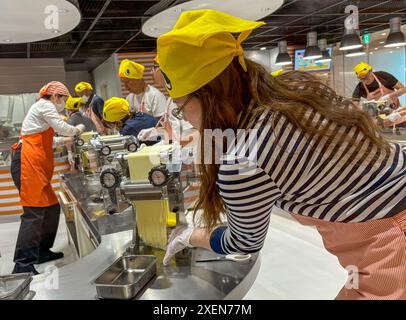 Un visitatore ha visto arrotolare l'impasto dei tagliatelle durante il processo di produzione dei tagliatelle istantanei al CupNoodles Museum. Il museo è dedicato alla storia degli spaghetti istantanei e alla storia di Nissin Foods, fondata da Momofuku Ando, l'inventore degli spaghetti istantanei e dei CupNoodles. Il museo ha due sedi, una a Osaka e l'altra a Yokohama, in Giappone. Foto Stock