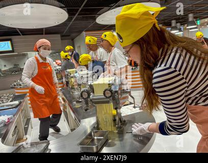 Un visitatore ha visto arrotolare l'impasto dei tagliatelle durante il processo di produzione dei tagliatelle istantanei al CupNoodles Museum. Il museo è dedicato alla storia degli spaghetti istantanei e alla storia di Nissin Foods, fondata da Momofuku Ando, l'inventore degli spaghetti istantanei e dei CupNoodles. Il museo ha due sedi, una a Osaka e l'altra a Yokohama, in Giappone. (Foto di Pongmanat Tasiri/SOPA Images/Sipa USA) credito: SIPA USA/Alamy Live News Foto Stock