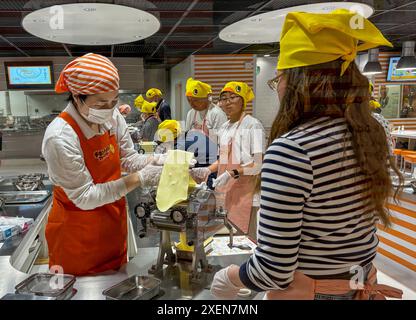 Un visitatore che ascolta un membro del personale del CupNoodles Museum durante il processo di produzione di spaghetti istantanei e cerca di creare i propri spaghetti istantanei personalizzati. Il museo è dedicato alla storia degli spaghetti istantanei e alla storia di Nissin Foods, fondata da Momofuku Ando, l'inventore degli spaghetti istantanei e dei CupNoodles. Il museo ha due sedi, una a Osaka e l'altra a Yokohama, in Giappone. (Foto di Pongmanat Tasiri/SOPA Images/Sipa USA) credito: SIPA USA/Alamy Live News Foto Stock