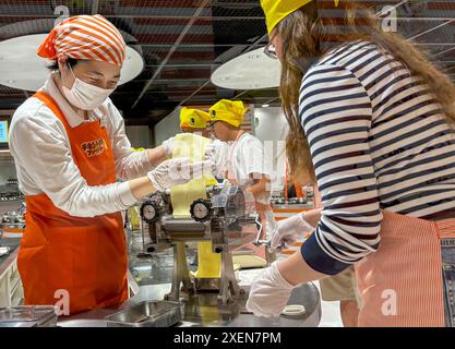 Un visitatore ha visto arrotolare l'impasto dei tagliatelle durante il processo di produzione dei tagliatelle istantanei al CupNoodles Museum. Il museo è dedicato alla storia degli spaghetti istantanei e alla storia di Nissin Foods, fondata da Momofuku Ando, l'inventore degli spaghetti istantanei e dei CupNoodles. Il museo ha due sedi, una a Osaka e l'altra a Yokohama, in Giappone. (Foto di Pongmanat Tasiri/SOPA Images/Sipa USA) credito: SIPA USA/Alamy Live News Foto Stock