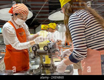 28 giugno 2024, S? EN, Osaka, Giappone: Un visitatore ha visto rotolare l'impasto dei tagliatelle durante il processo di produzione dei tagliatelle istantanei al Museo CupNoodles. Il museo è dedicato alla storia degli spaghetti istantanei e alla storia di Nissin Foods, fondata da Momofuku Ando, l'inventore degli spaghetti istantanei e dei CupNoodles. Il museo ha due sedi, una a Osaka e l'altra a Yokohama, in Giappone. (Credit Image: © Pongmanat Tasiri/SOPA Images via ZUMA Press Wire) SOLO PER USO EDITORIALE! Non per USO commerciale! Crediti: ZUMA Press, Inc./Alamy Live News Foto Stock