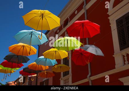 Ombrelli colorati appesi su via Belvedere nella città vecchia di Novigrad in Croazia; Novigrad, regione Istria, Croazia Foto Stock