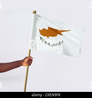 Mano nera africana tesa che tiene la bandiera nazionale di Cipro isolata su sfondo bianco, protesta, sventolamento, pugno, libertà Foto Stock