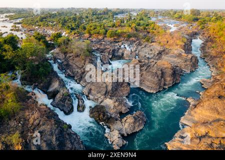 Vista droni delle bellissime cascate li Phi Somphamit con una corrente che scorre intorno alla roccia e una vegetazione lussureggiante; Don Khon, Khon Tai, Laos Foto Stock