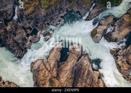 Vista direttamente dall'alto di una porzione delle cascate li Phi Somphamit con una corrente che scorre intorno alla roccia; Don Khon, Khon Tai, Laos Foto Stock