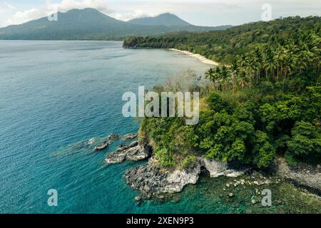 Splendido paesaggio di vegetazione lussureggiante e spiaggia di sabbia bianca a Pantai Canada (Canada Beach) lungo la costa di North Sulawesi, Indonesia Foto Stock