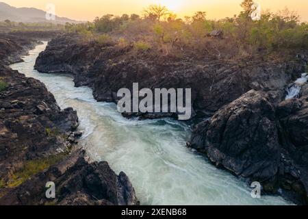 Fiume che scorre con la calda luce del tramonto alle cascate li Phi Somphamit in Laos; Khon Tai, Laos Foto Stock